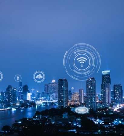 Cityscape at night with illuminated buildings and icons representing connectivity between different locations.